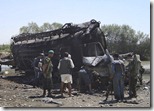 Afghan police look at fuel tanker destroyed by NATO jets