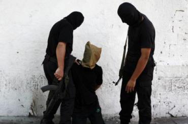 A Hamas militant grabs a Palestinian suspected of collaborating with Israel, before being executed in Gaza City August 22, 2014. REUTERS/Stringer
